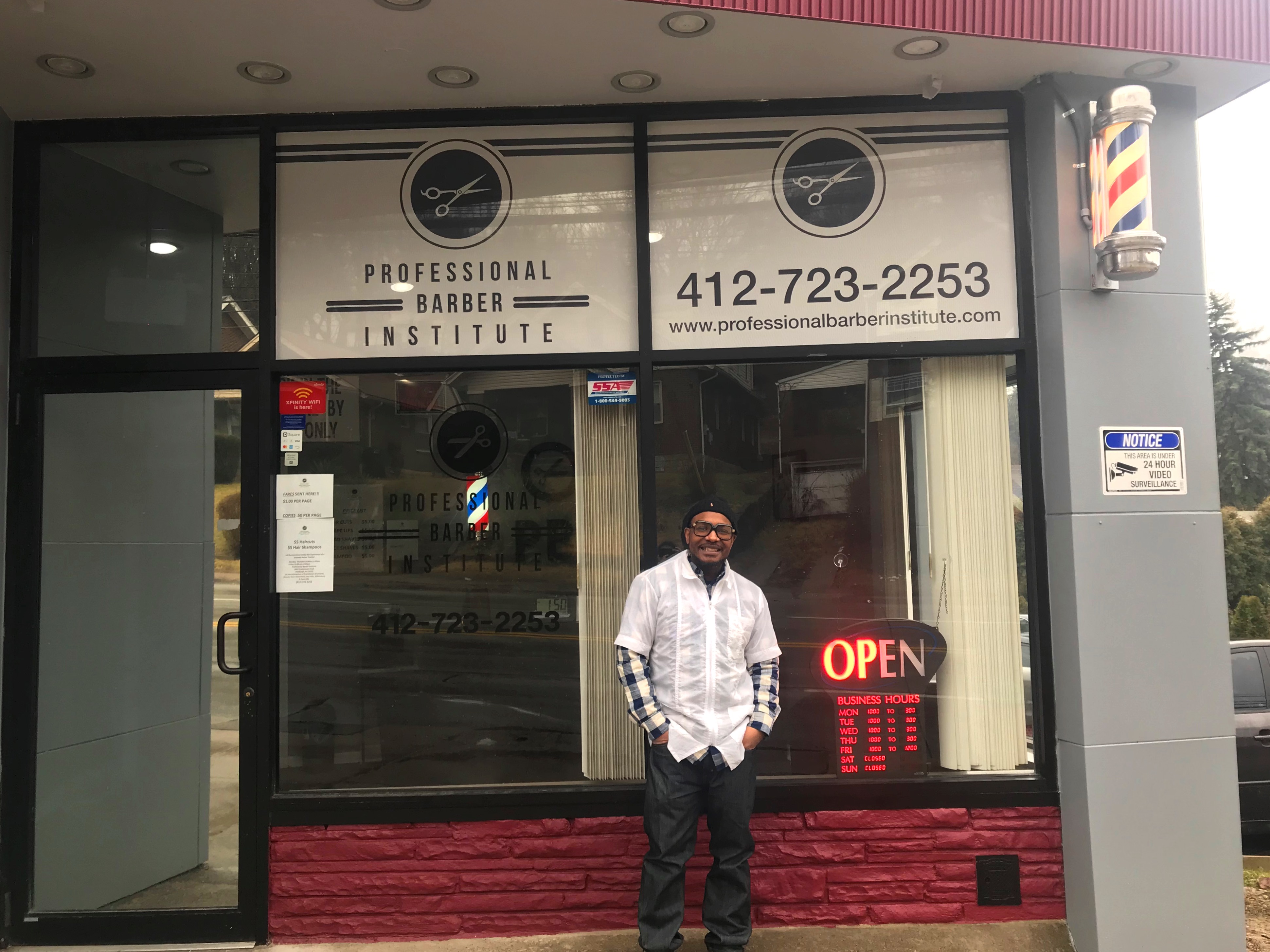 Wahad Ansari, owner of Professional Barber Institute, stands in front of his storefront.