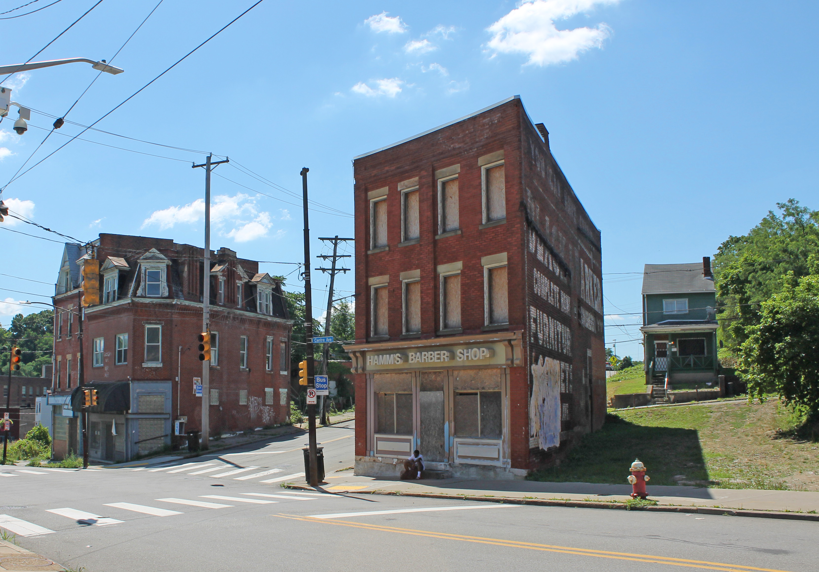 The former Hamm's Barber Shop building stands three-stories tall and boarded up on Centre Avenue in the Hill District.