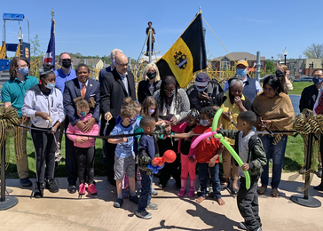 Elected officials, partners, community leaders, and youth cut a ribbon