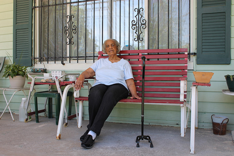 Larimer resident Wilma Jones-Cox sits on a bench on her front porch