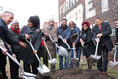 Partners smile with shovels in their hands during a groundbreaking ceremony