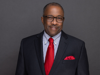 Headshot of Richard Snipe, smiling and dressed in a suit